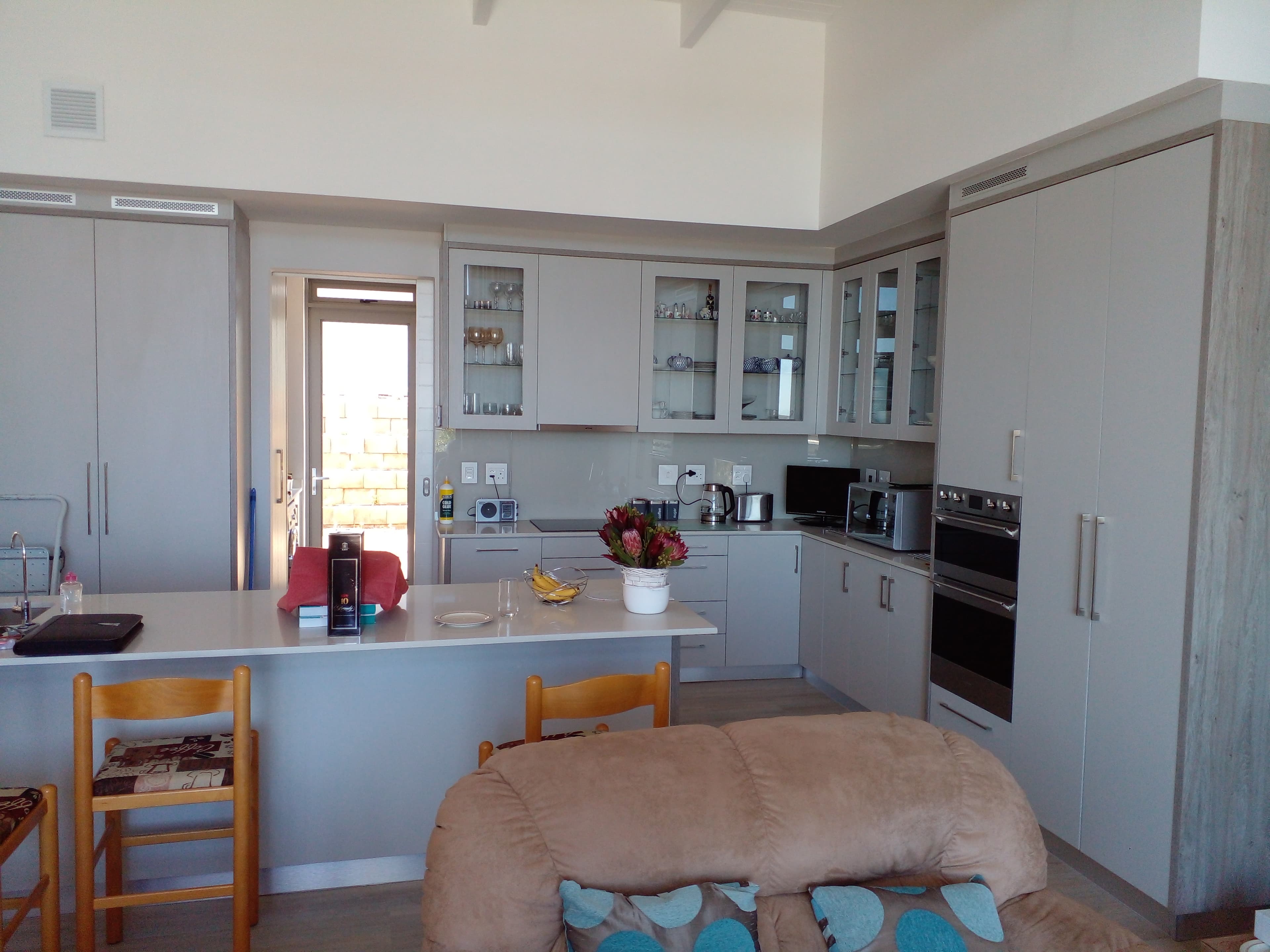 Grey melamine kitchen with glass-front cabinets and island